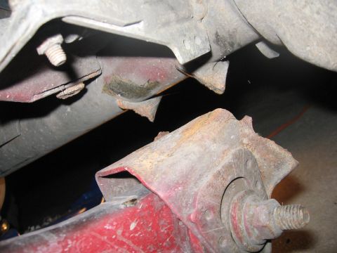 1974 Ford F-100 - Close-up view of heavily rusted vehicle frame components and fasteners.
