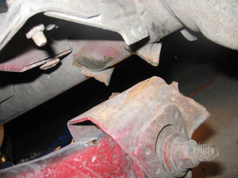 Close-up of rusted metal brackets and bolts on a vehicle frame