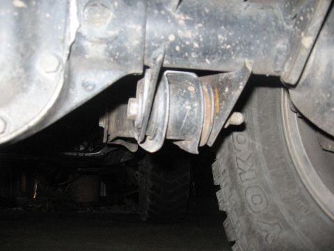 1974 Ford F-100 - Detail of a vehicle's rear suspension system, showing wear and tear on a metal component and part of a tire.