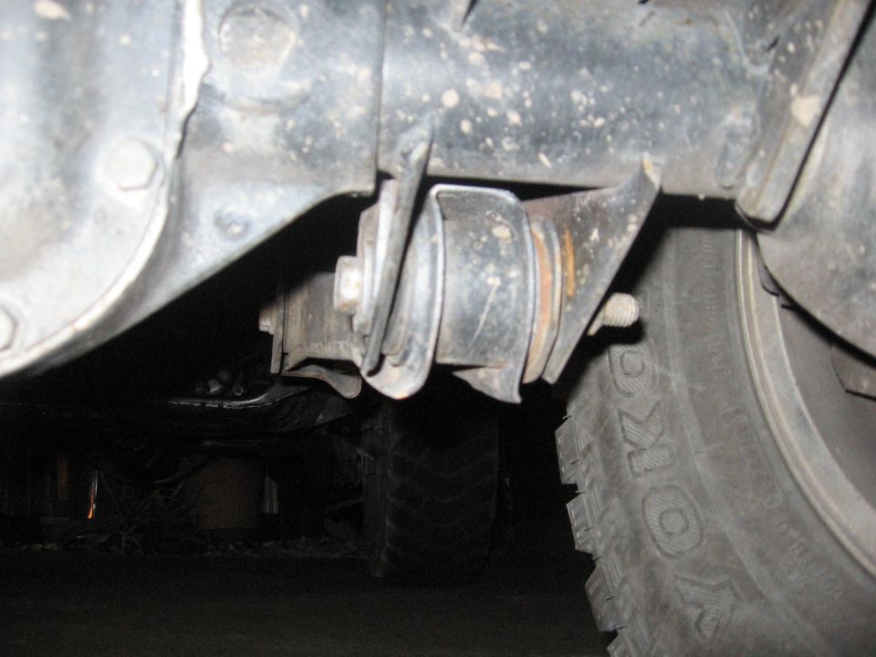 Close-up of a rusty suspension component and tire tread