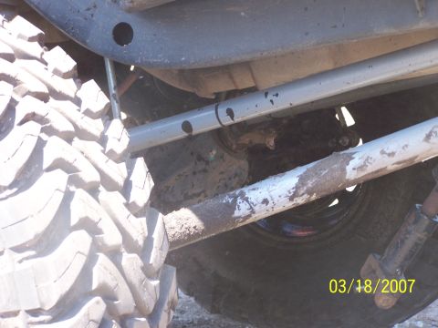 1989 Ford Bronco - Undercarriage view of a vehicle with large tires and suspension parts, showing signs of off-road use.