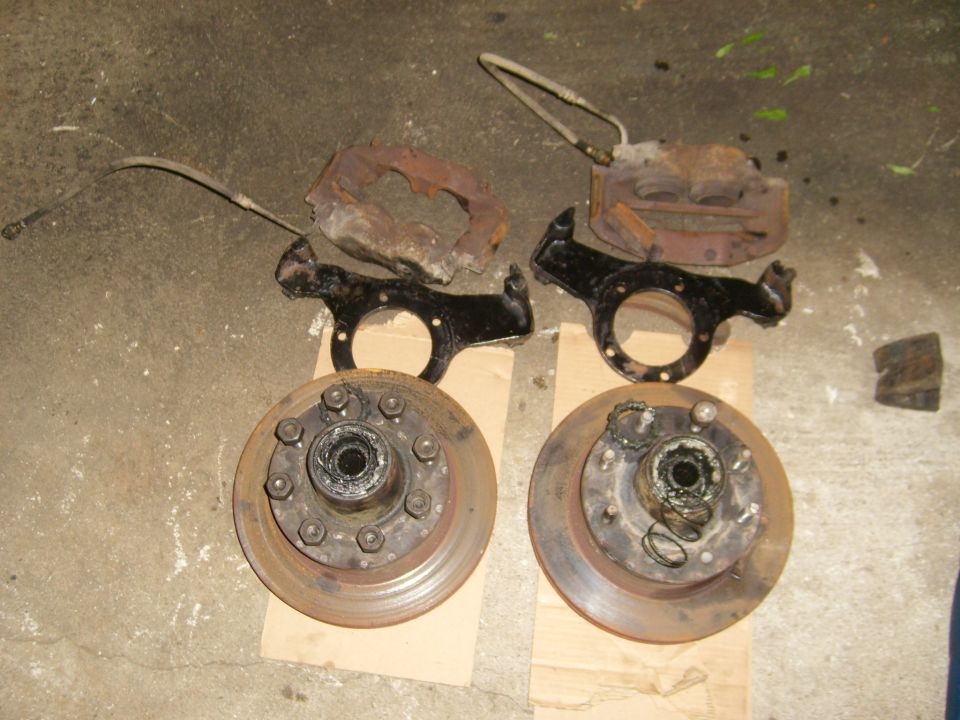 Pair of rusty brake rotors and calipers with mounting hardware