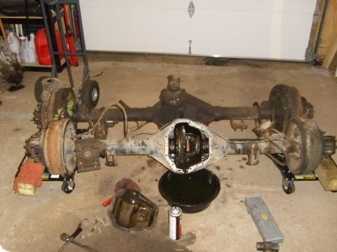 1994 Ford Bronco - Rear axle assembly from a 1994 Ford Bronco, differential open for inspection. Parts are on dollies.