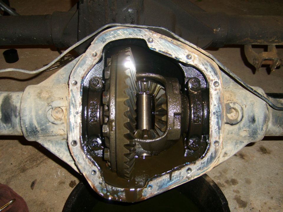 Open differential housing with gears visible, showing oil and gasket