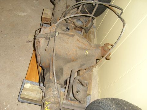 1994 Ford Bronco - Rusty Ford Bronco rear axle assembly with brake lines, likely for a 1994 model.