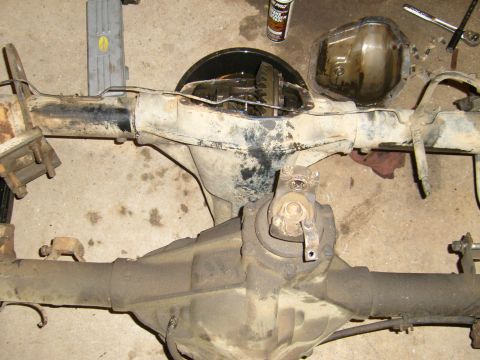 1994 Ford Bronco - Differential axle assembly with differential cover removed, showing gears. Some rust and grime are visible.