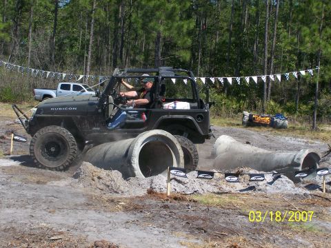 1989 Ford Bronco - A black Jeep Wrangler Rubicon tackles an off-road obstacle course with concrete pipes in 2007.