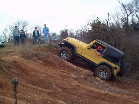 1978 Ford Bronco - Off-road vehicle navigates challenging terrain with spectators present.