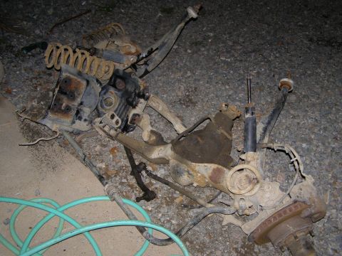 1993 Ford Bronco - Vehicle suspension components laid out on the ground, possibly for repair or replacement.