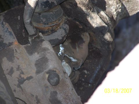 1989 Ford Bronco - Close-up of a rusty vehicle suspension component, likely part of the front end.