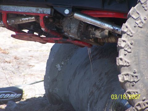 1989 Ford Bronco - Close-up view of the undercarriage and large tire of a modified off-road vehicle.
