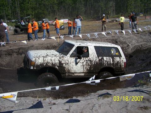 1989 Ford Bronco - Muddy 1989 Ford Bronco navigates a challenging mud pit during an off-road event.
