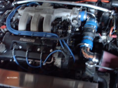 1995 Ford Probe - Engine bay detail with aftermarket intake and Mazda branding on the valve cover.