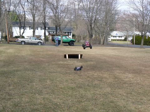 1994 Ford Bronco - Remote control cars are being operated in a suburban yard with houses and trees in the background.