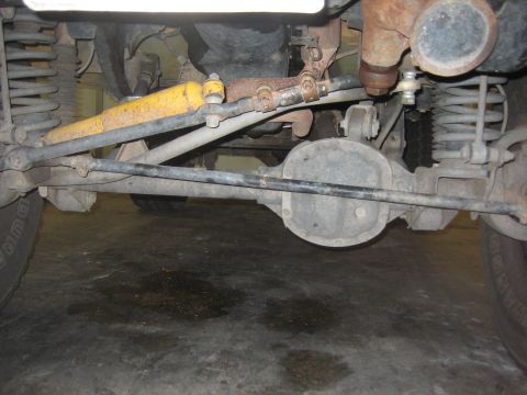 2001 Jeep Wrangler - Close-up view of the front axle and suspension system, including a yellow shock absorber and steering linkage.