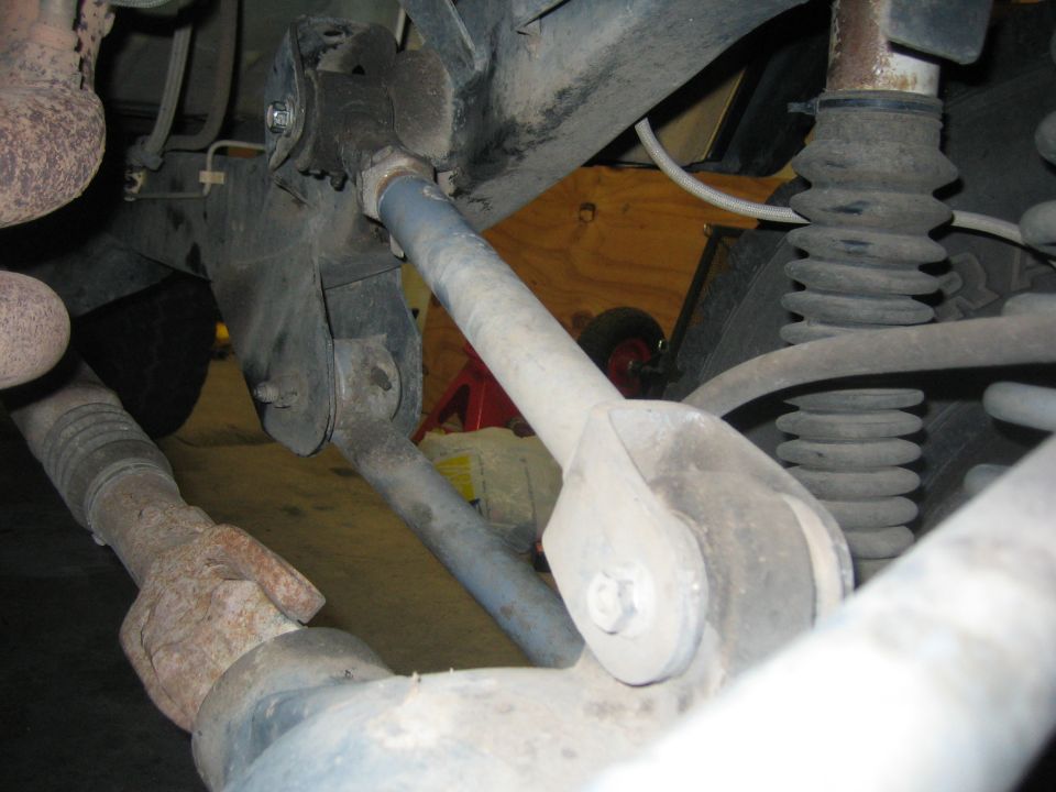 Close-up of rear suspension parts, including control arms and shock absorber boot