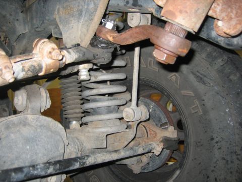 2001 Jeep Wrangler - Close-up view of the front suspension system of a 2001 Jeep Wrangler, highlighting mechanical components.
