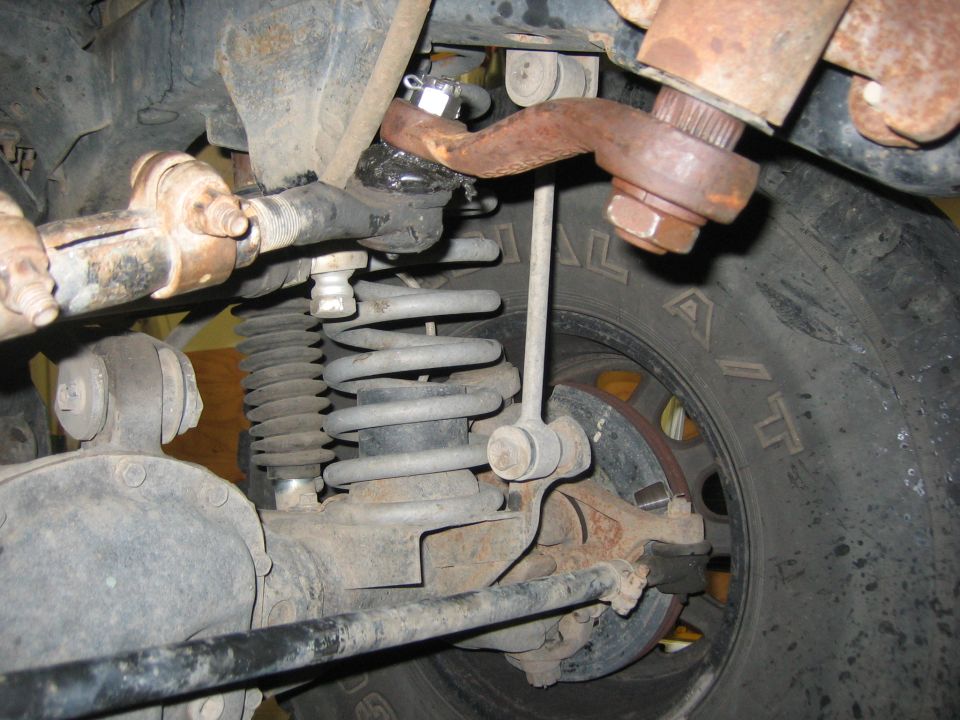 2001 Jeep Wrangler front suspension with rusty tie rod and coil spring