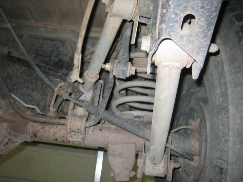 2001 Jeep Wrangler - Close-up view of a vehicle's rear suspension system, highlighting the shock absorber and coil spring assembly.