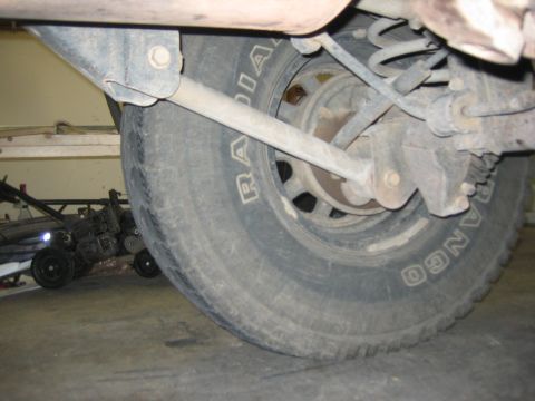 2001 Jeep Wrangler - Rear axle and tire detail of an unidentified vehicle, showing suspension parts.
