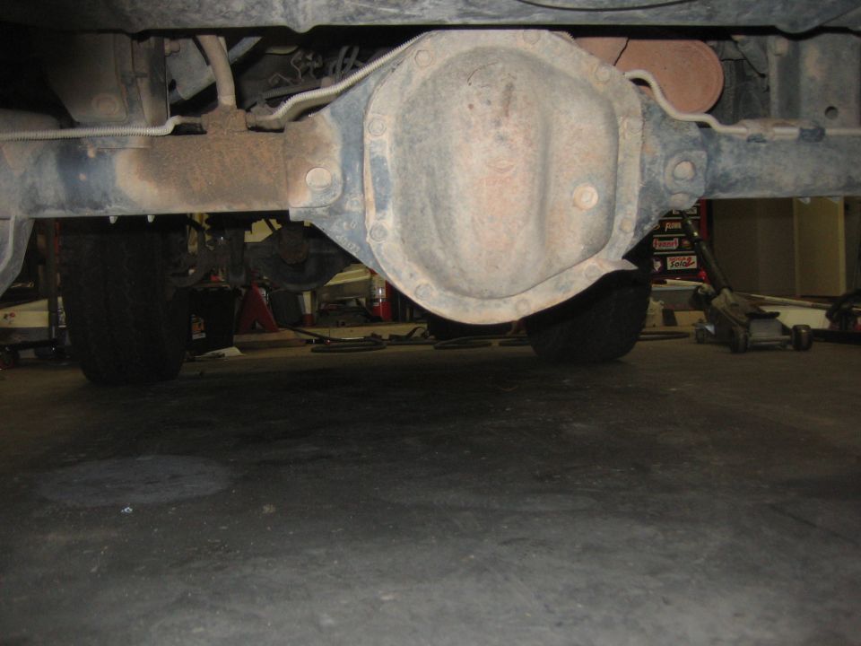 Rear differential and suspension of a vehicle, viewed from underneath. Tires and part of the frame are visible