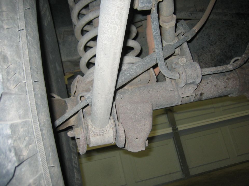Close-up of vehicle's rear suspension components, including coil spring and shock absorber mount