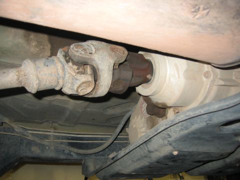2001 Jeep Wrangler - Underside view of a vehicle's driveshaft and transfer case assembly.