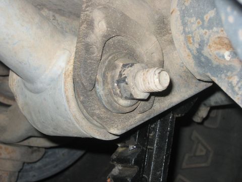 2001 Jeep Wrangler - Vehicle suspension component with a large bolt and bushing visible.