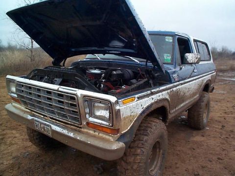 1978 Ford Bronco - Mud-covered 1978 Ford Bronco with its hood open, revealing the engine compartment.
