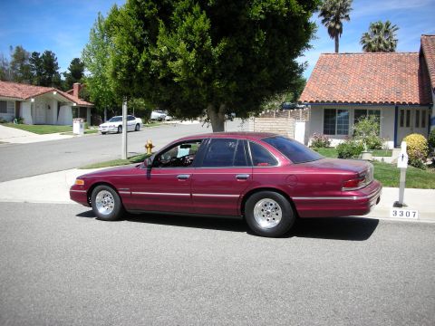 1992 Ford Crown Victoria - Maroon 1992 Ford Crown Victoria modified with drag wheels, parked curbside in a residential area.