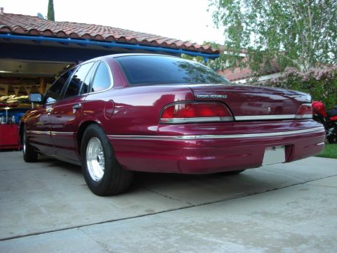1992 Ford Crown Victoria - This 1992 Ford Crown Victoria LX is shown from the rear, custom wheels and a deep maroon paint job.