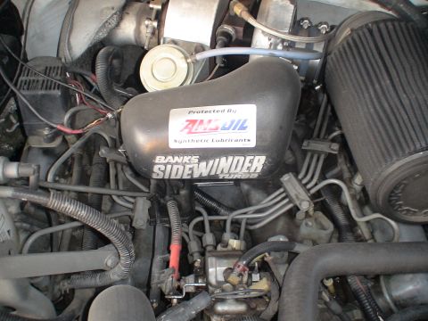 1993 Ford C-350 (Centurion Conversions) - Close-up of an engine bay, highlighting a Banks Sidewinder turbo system and Amsoil branding.