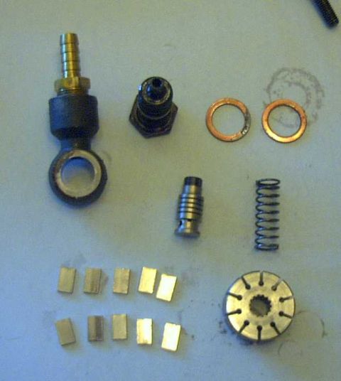 1997 Ford Taurus - Disassembled steering system parts are arranged on a flat surface, including a spring, washers, and metal blocks.