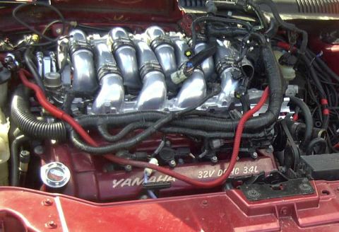 1997 Ford Taurus - The engine bay shows a V6 engine with prominent intake runners and "YAMAHA 32V DOHC 3.4L" markings.