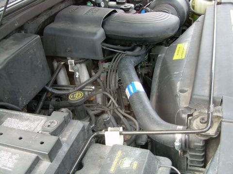 1997 Ford F-150 - Close-up view of a vehicle's engine bay, showing various engine components and hoses.