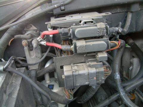 1997 Ford F-150 - Close-up of a vehicle's engine bay wiring and fuse box components.