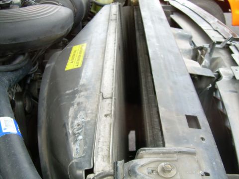 1997 Ford F-150 - Close-up view of the radiator and fan shroud assembly, showing a yellow caution sticker.
