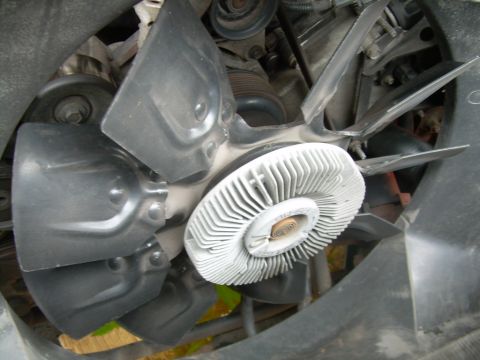 1997 Ford F-150 - Close-up view of an engine fan clutch, showing its ribbed metal hub and fan blades.
