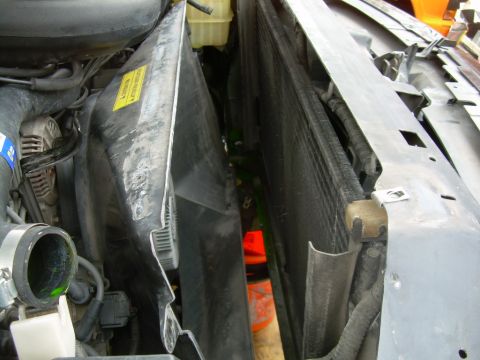 1997 Ford F-150 - Radiator and fan shroud assembly, with green coolant visible in the engine bay.