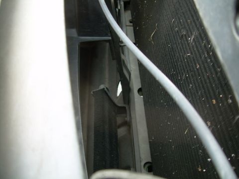 1997 Ford F-150 - The radiator and condenser fins are visible, along with a gray hose and some debris.