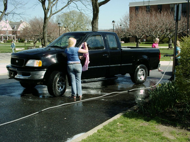Black 1997 Ford F-150 pickup truck being washed by a woman