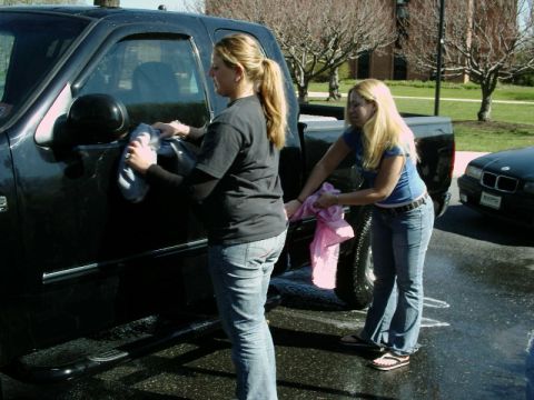 1997 Ford F-150 - Two women are washing a black pickup truck in an outdoor setting.