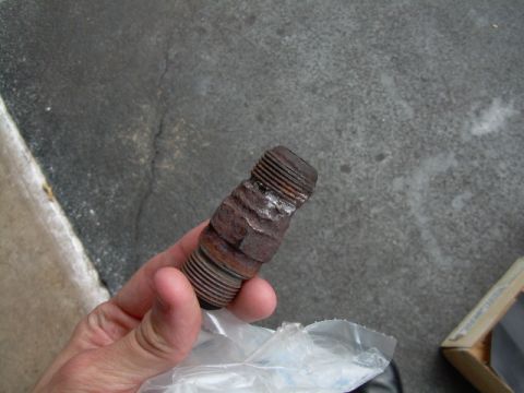 1997 Ford F-150 - A heavily rusted metal part with visible threads is held in a hand.