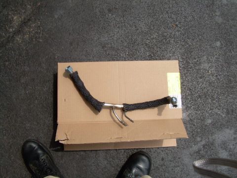 1997 Ford F-150 - A close-up view of an EGR air tube, laid out on a piece of cardboard.