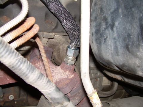 1997 Ford F-150 - Close-up view of an engine component, likely an EGR air tube connection, showing hoses and exhaust manifold.