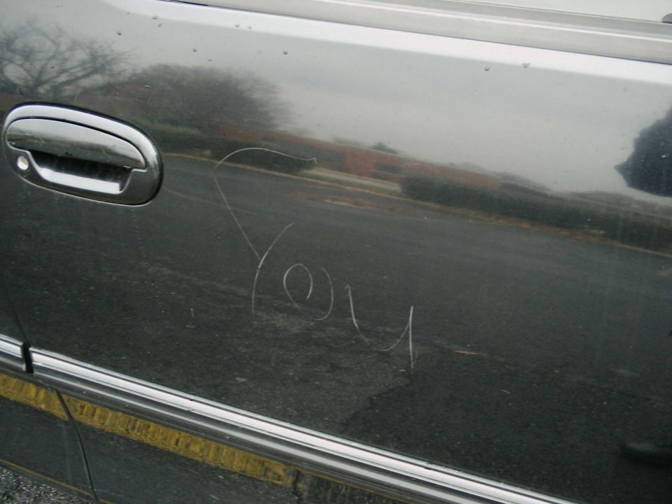 Car door with 'You' scratched into it