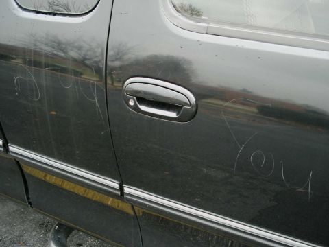 1997 Ford F-150 - Scratched words on the side of a dark truck door are visible.