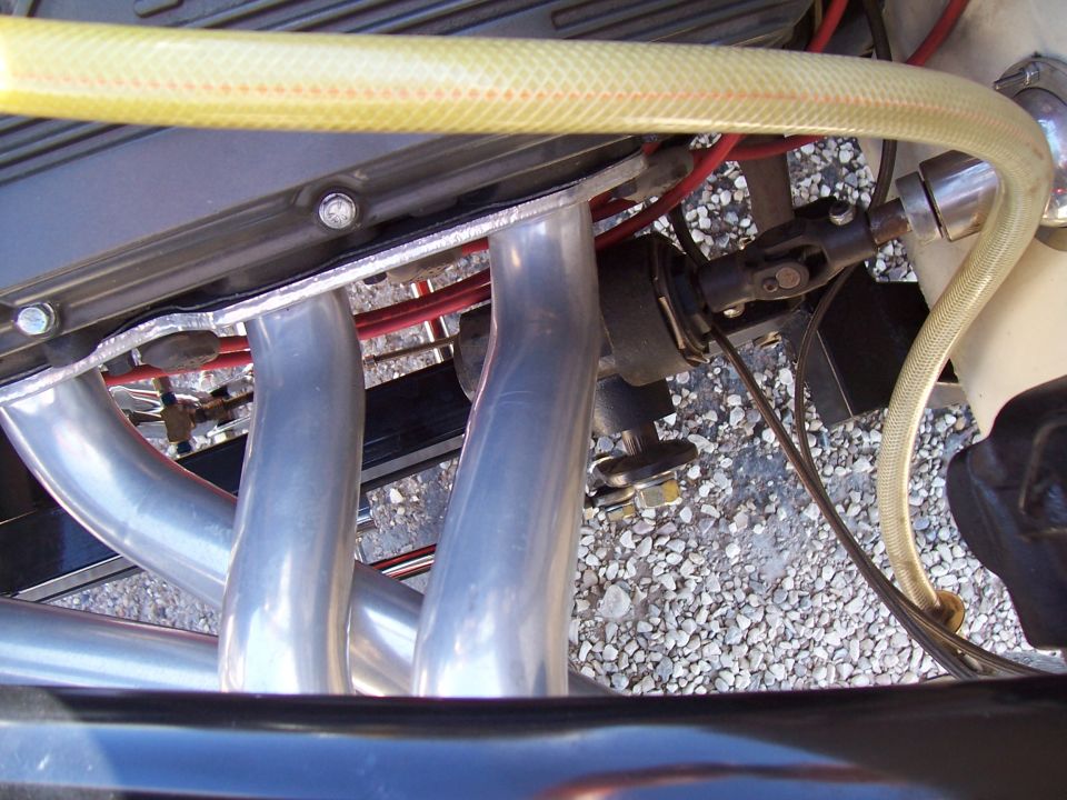 Close-up of an engine's exhaust manifold and a steering column U-joint