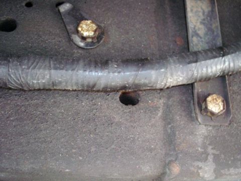 1997 Ford F-150 - Close-up of a vehicle's undercarriage, focusing on a wire harness and mounting hardware.