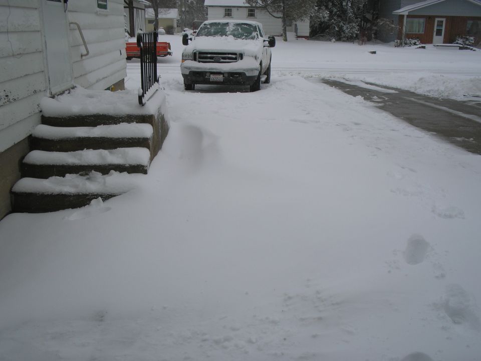 Snow-covered driveway with a pickup truck